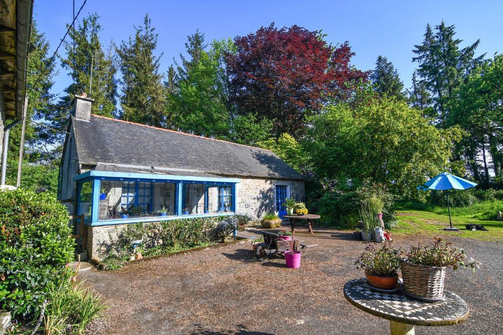 un petit cottage en pierre avec une table et un banc dans l'établissement La Maison Bleue, à Lanfains