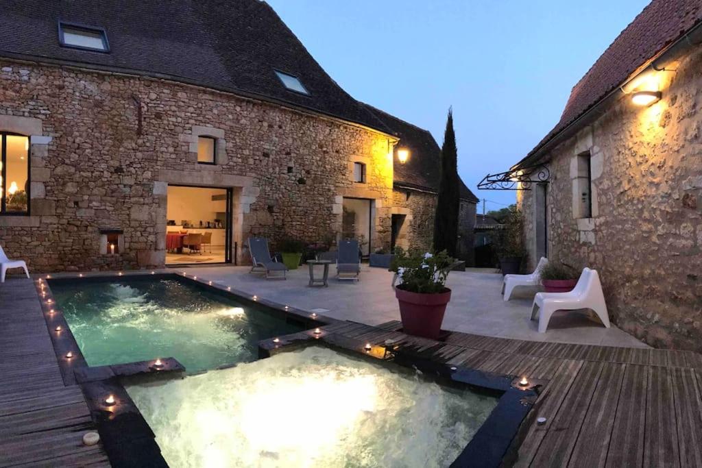 a backyard with a swimming pool next to a building at Le Clos de Peyruzel, Daglan in Daglan