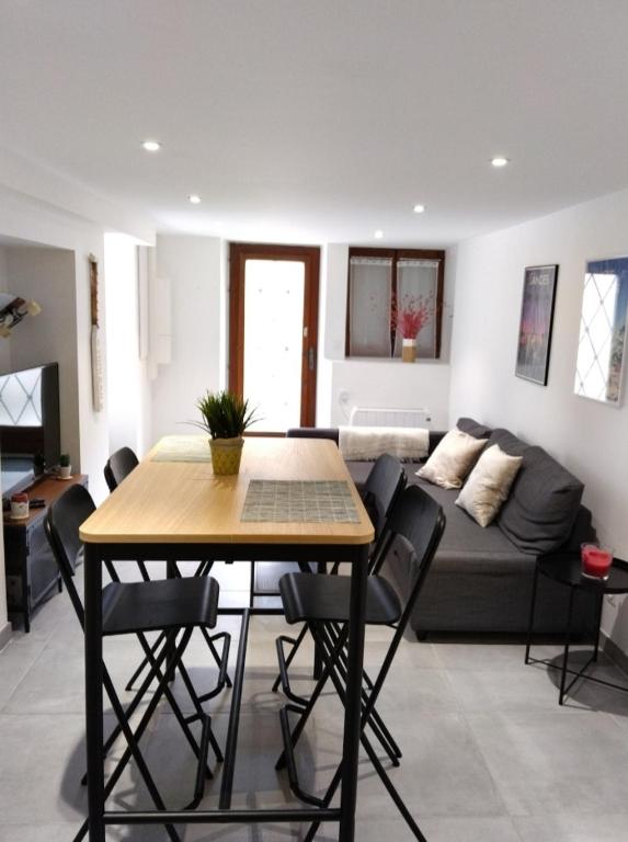 un salon avec une table et un canapé dans l'établissement Maison Cosy Calme Central Bus Lac Kir, à Plombières-lès-Dijon