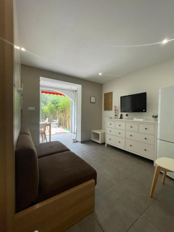 un salon avec un canapé et une télévision dans l'établissement Charmant Studio, à La Londe-les-Maures