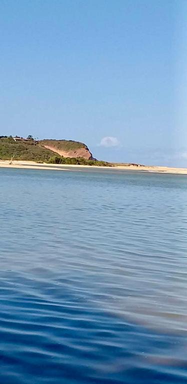 a large body of water with a beach in the background at Jacumã AP in Conde