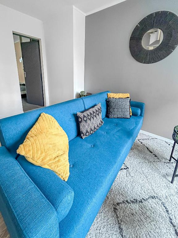 un canapé bleu avec des coussins dans un salon dans l'établissement 405- saint brieuc, à Saint-Brieuc
