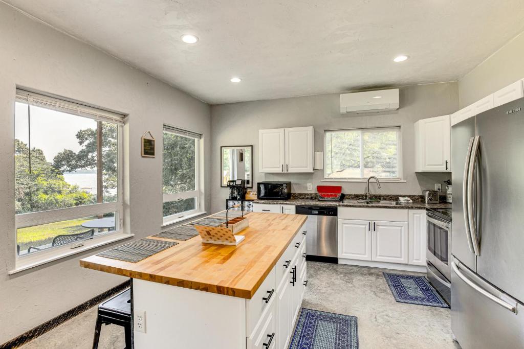 eine Küche mit weißen Schränken und einer Holzarbeitsplatte in der Unterkunft Frankston Vacation Rental Walk to Lake Palestine! in Coffee City