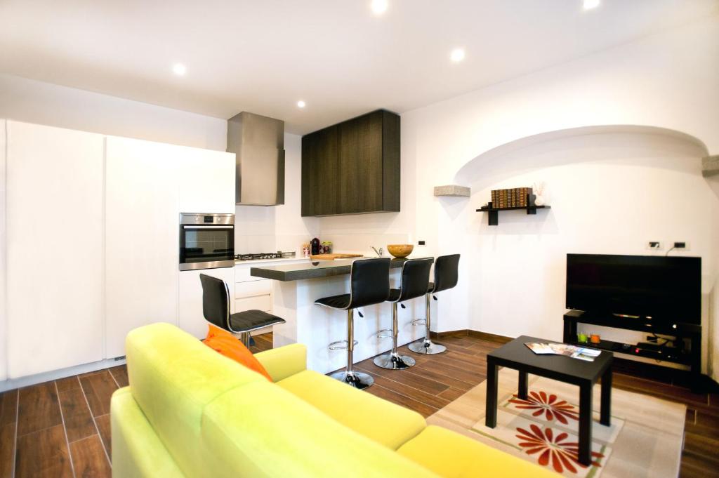 a living room with a yellow couch and a kitchen at Appartamento Melissa in Santa Maria Maggiore