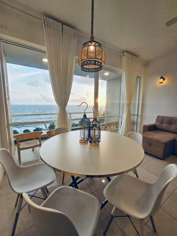 a dining room with a table and chairs and the ocean at Secret Passage in Uswetakeiyawa