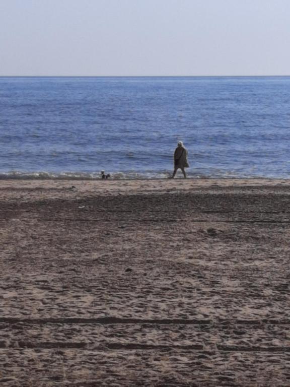een persoon die op een strand in de buurt van de oceaan loopt bij No.21 BERMUDA in Hemsby