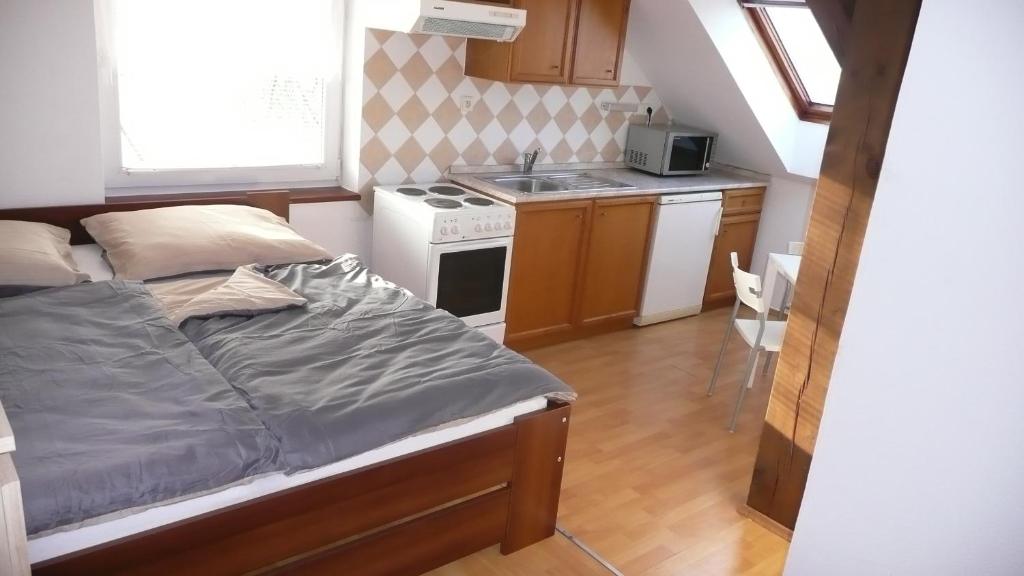 a small bedroom with a bed and a kitchen at Apartments U Cara in České Budějovice