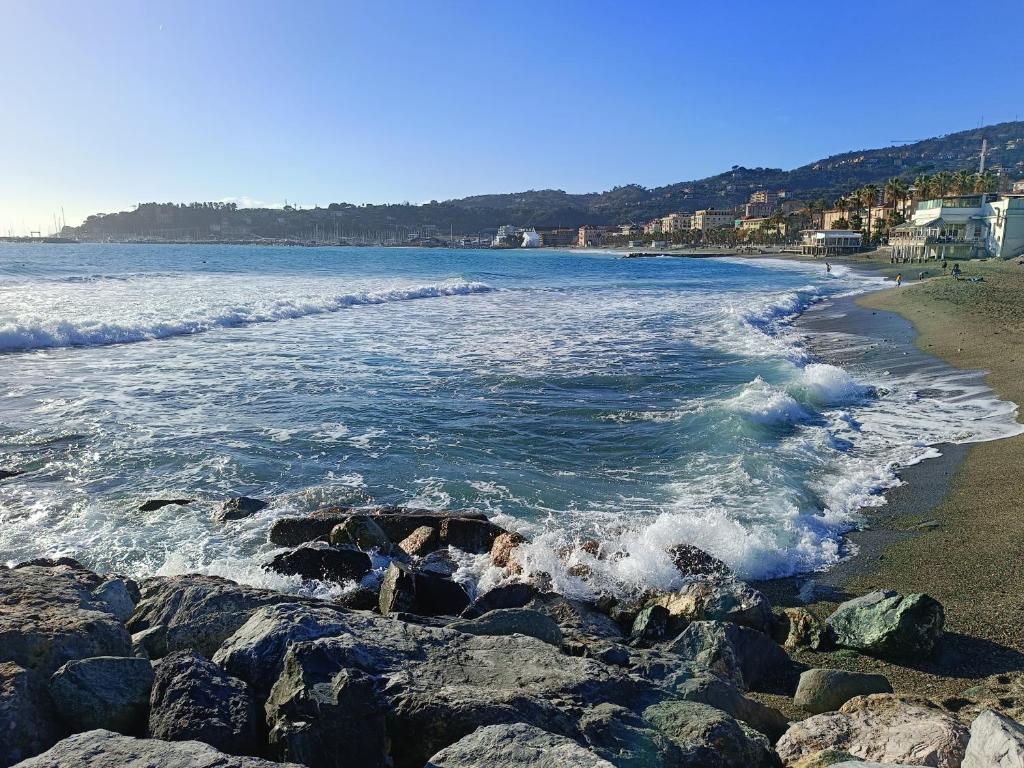 a beach with waves crashing on the rocks at Grazioso bilocale in Giusvalla
