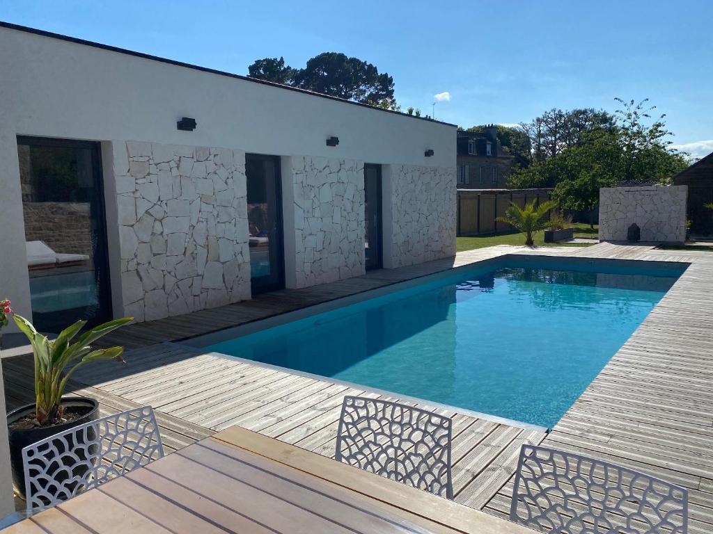 - une piscine dans un jardin avec une terrasse en bois dans l'établissement VILLA Pablo, à Guingamp
