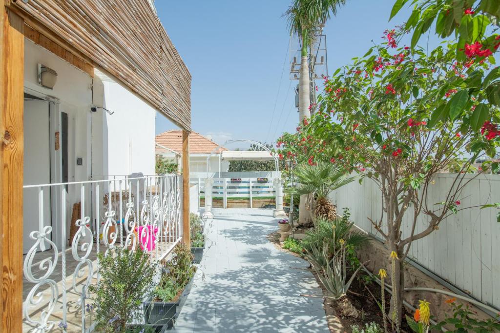 Ein Gehweg führt zu einem Haus mit Blumen. in der Unterkunft Villa Li Eilat in Eilat