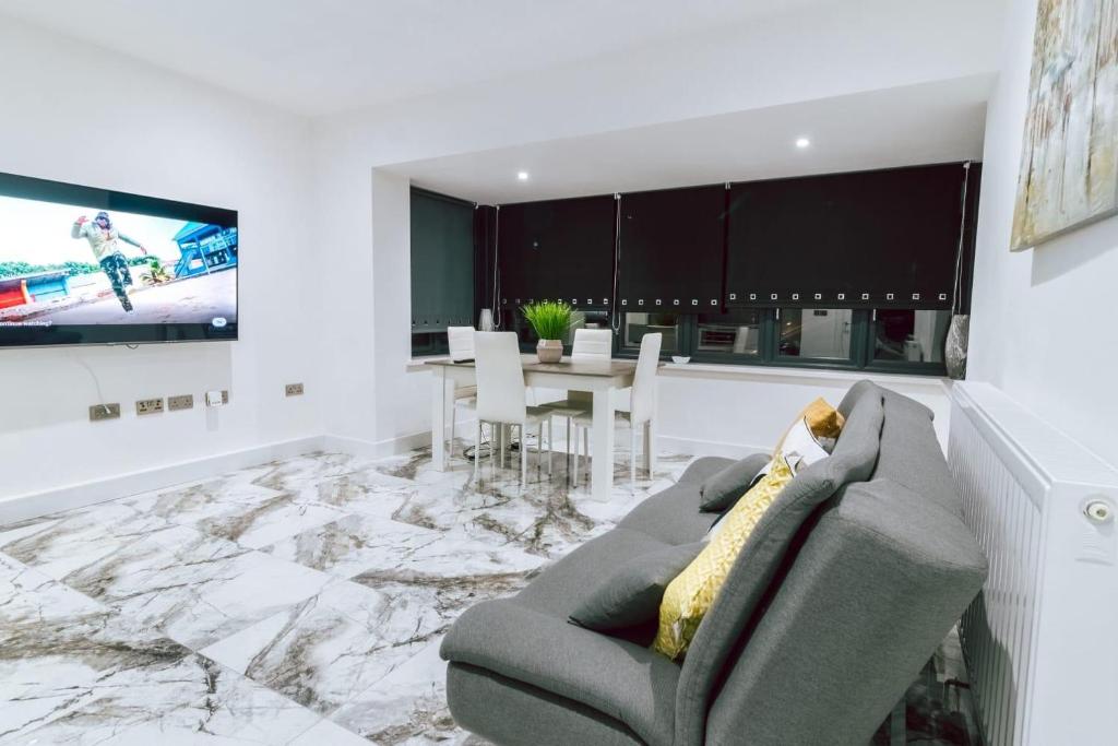 a living room with a couch and a dining room at Purley 2 Bed Flat in Purley