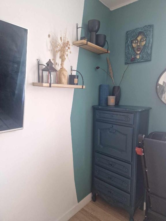 une chambre avec une commode et des étagères sur le mur dans l'établissement Le jasmin, à Aulnay-sous-Bois