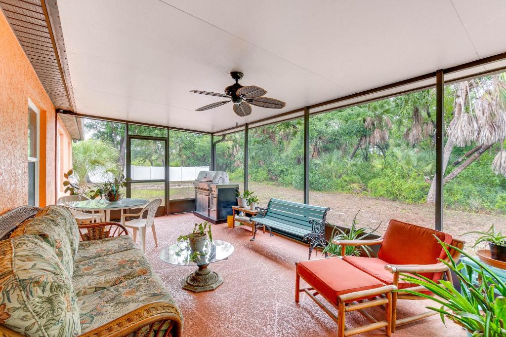 a living room with a couch and chairs and windows at North Port Home with Charming Lanai about 7 Mi to Beach in North Port