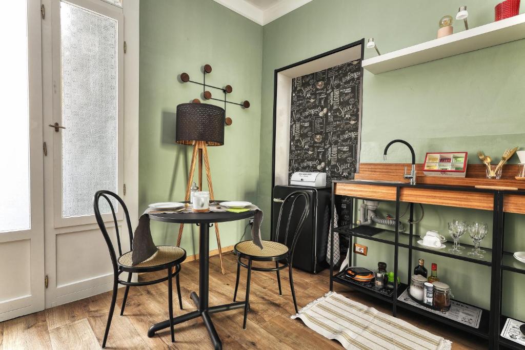 a table and chairs in a room with green walls at Maison Saporiti in Vigevano