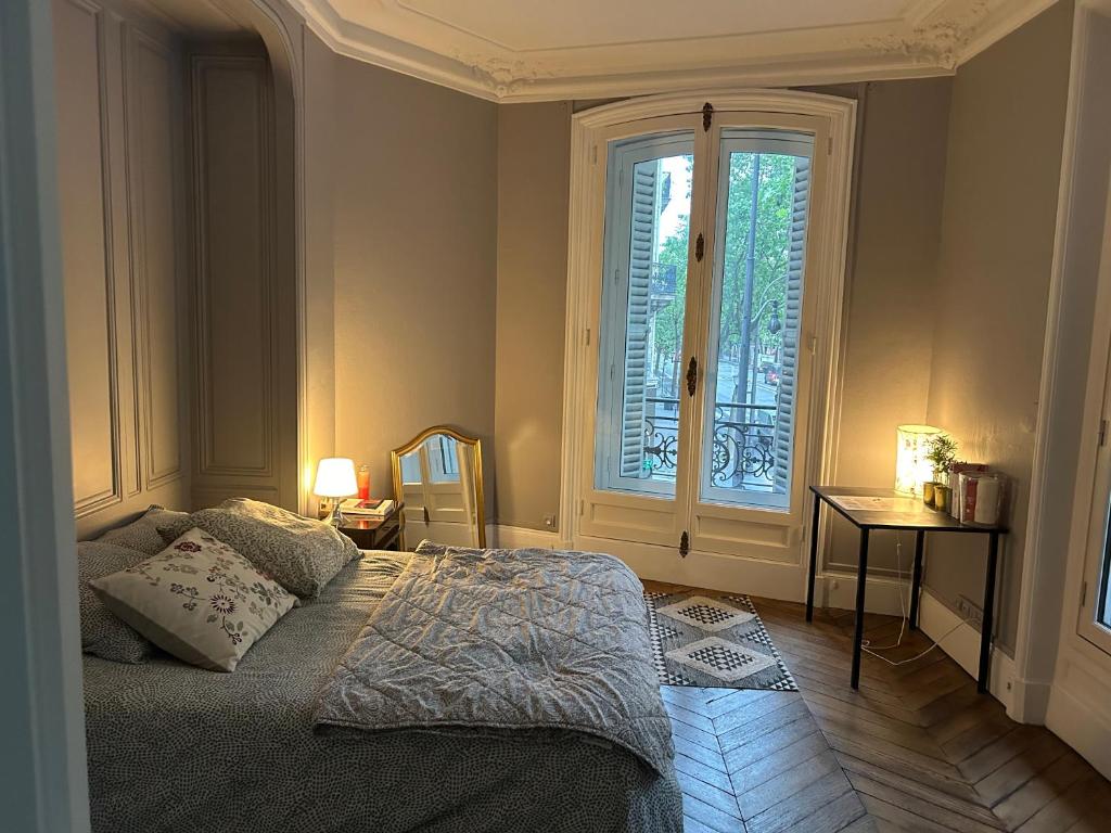 une chambre avec un lit et une grande fenêtre dans l'établissement Monceau Paris 8, à Paris