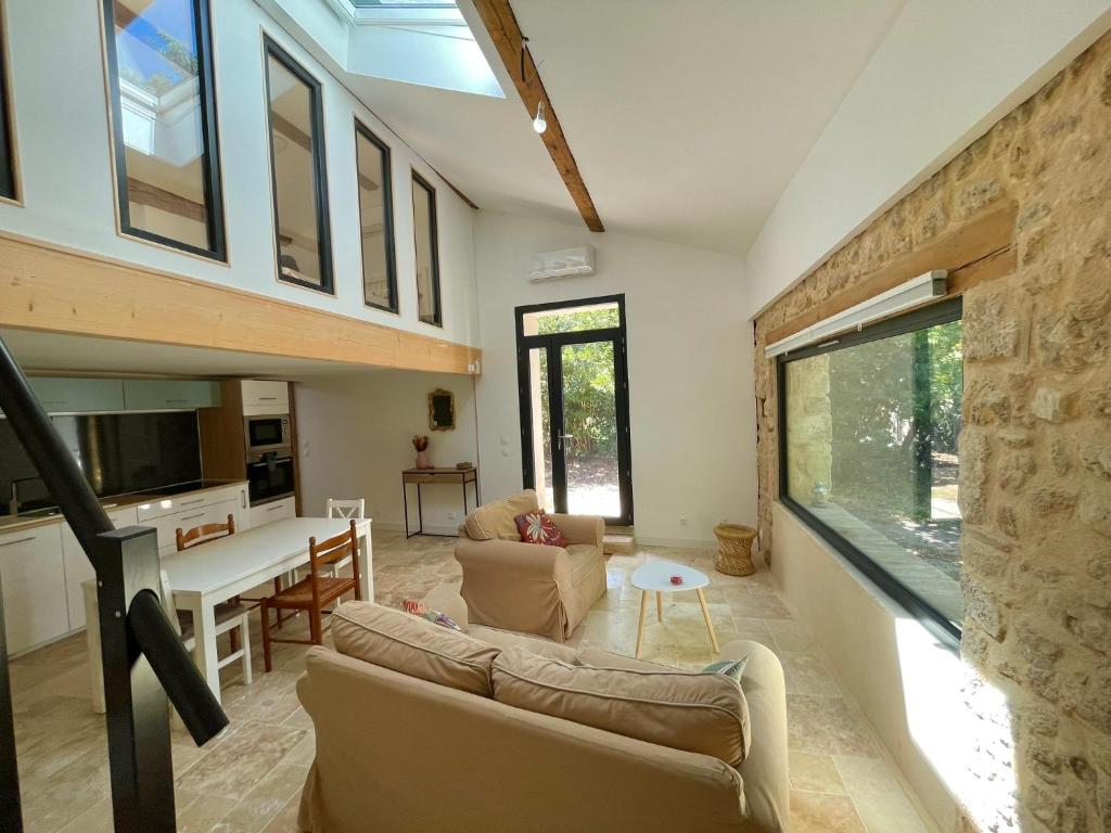 un salon avec un canapé et une table dans l'établissement Grange rénovée, jardin privé et piscine partagée, à Poussan
