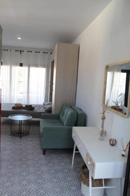 a living room with a green couch and a table at Honey Studio in Colmenar
