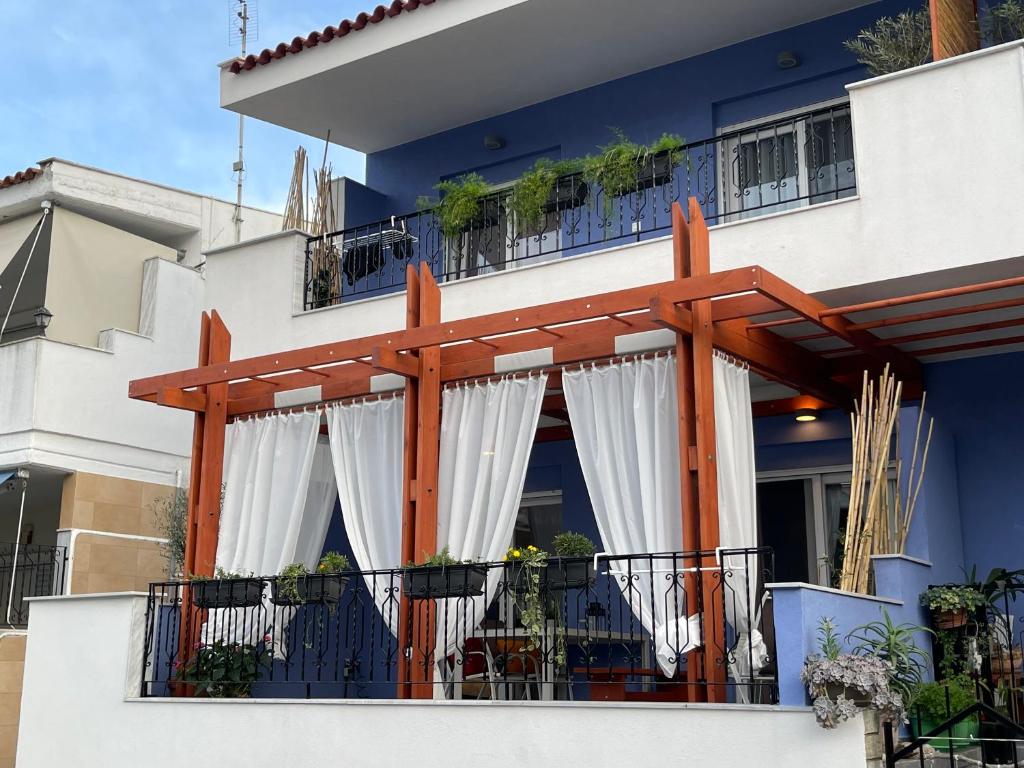a balcony with white curtains on a building at Gaia Apartments in Hanioti