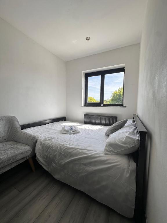 a bedroom with a bed and a chair and a window at Cozy double near Train Station in Birmingham