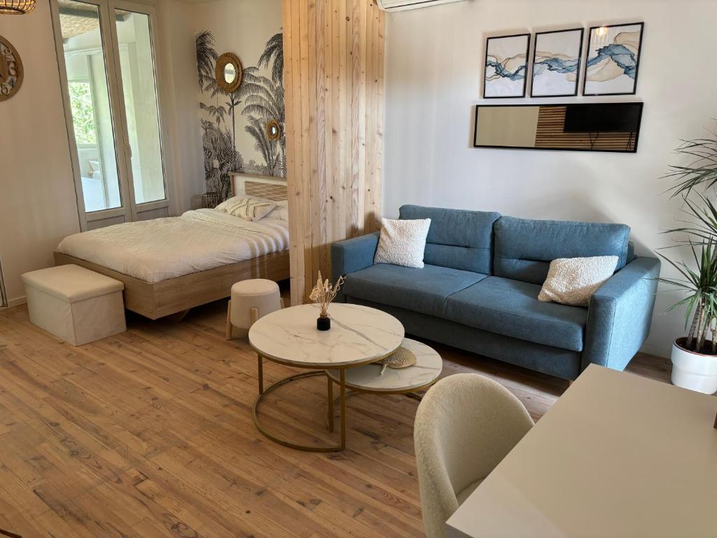 - un salon avec un canapé bleu et un lit dans l'établissement Studio 3, à Avignon