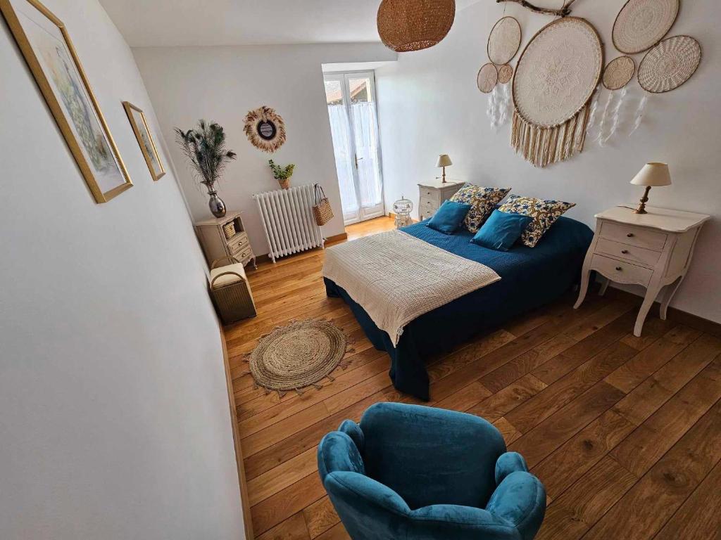 - une chambre avec un lit bleu et une chaise dans l'établissement Le Moulin de Chazelle, à Cormatin