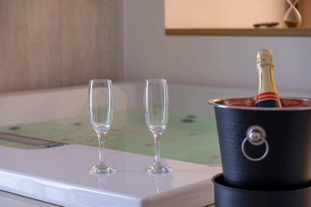 two wine glasses and a bucket with a bottle of champagne at B&B Le Muse in Mondello