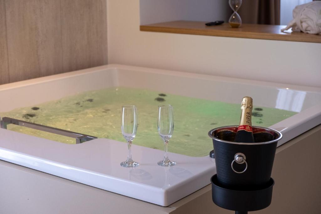 a bath tub with two wine glasses and a champagne bottle at B&B Le Muse in Mondello