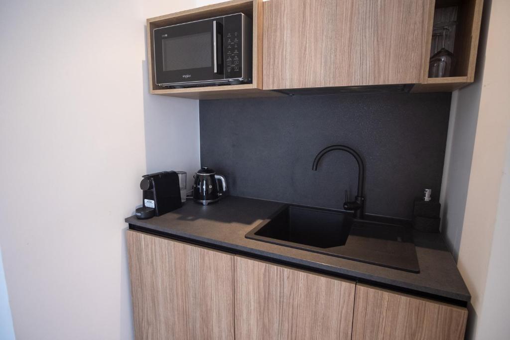a kitchen with a sink and a microwave at B&B Le Muse in Mondello