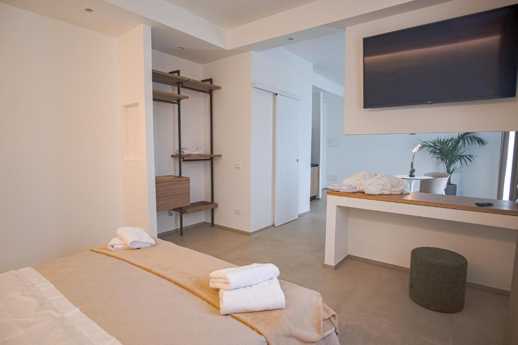 a bedroom with a bed and a desk with a television at B&B Le Muse in Mondello