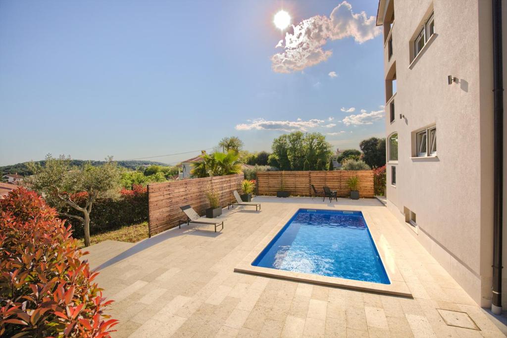 a swimming pool in the middle of a yard at Villa Harmony - Apartments in Banjole