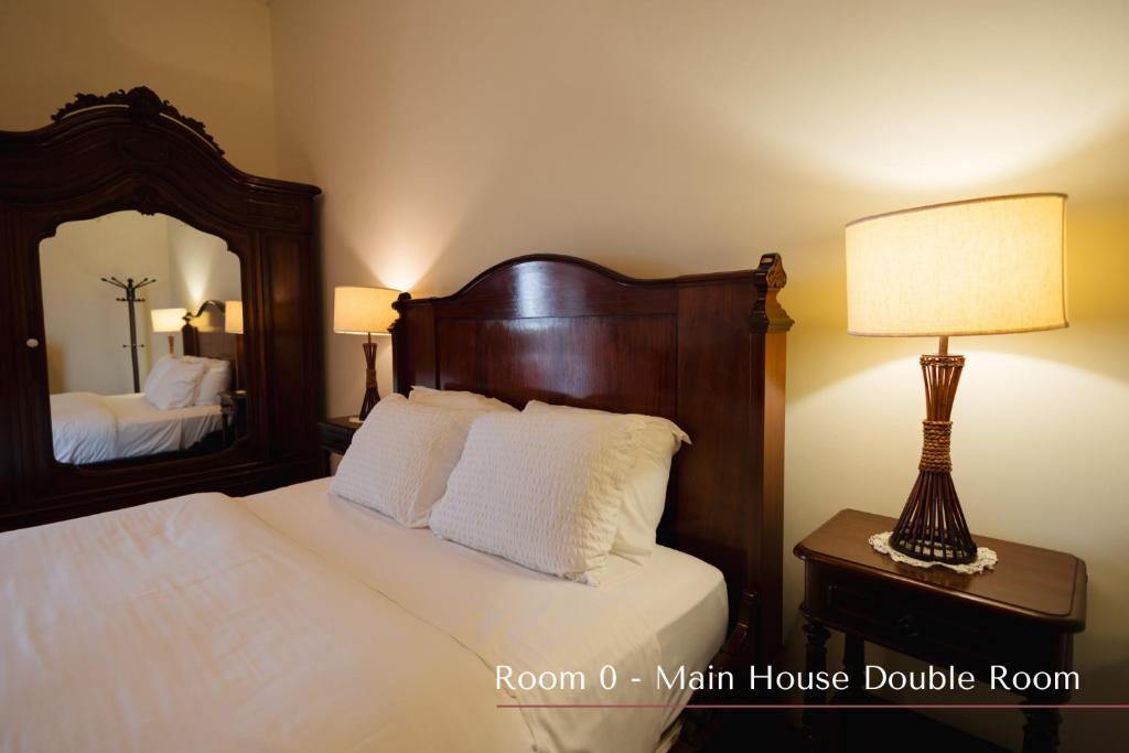 a bedroom with a bed and a lamp and a mirror at Solar de Lalém in Maia