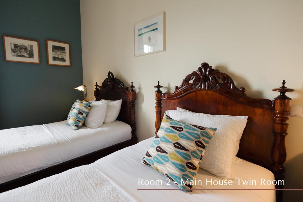 a bedroom with two beds and two pillows at Solar de Lalém in Maia