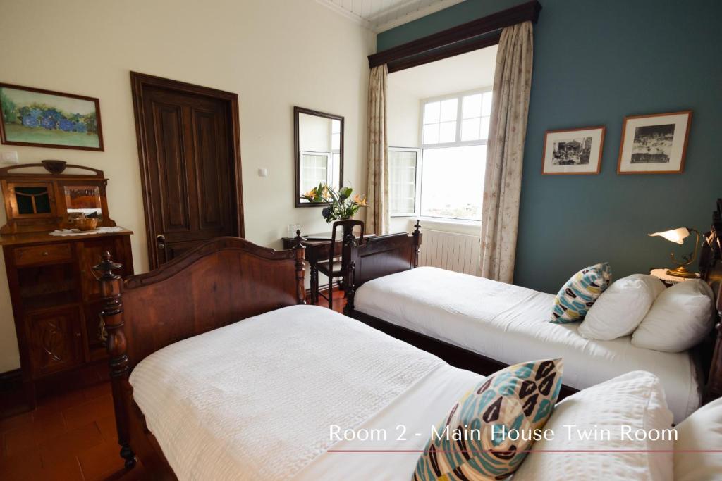 a bedroom with two beds and a window at Solar de Lalém in Maia