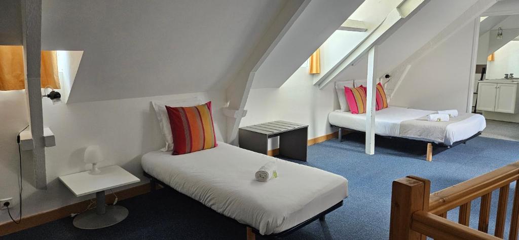 a small room with two beds and a mirror at hotel terminus auray in Auray