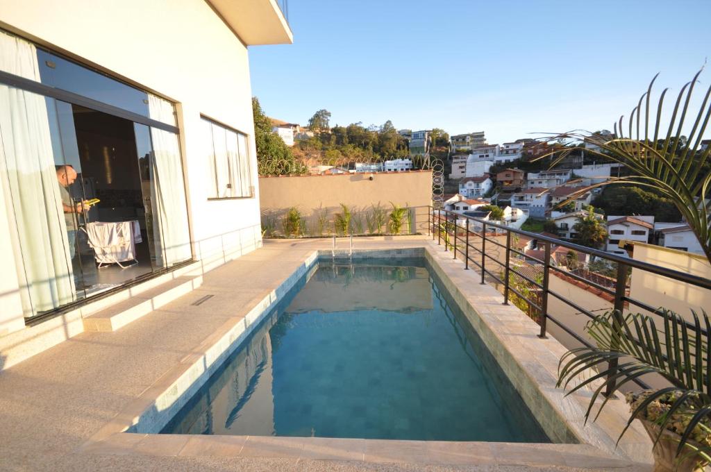 a swimming pool on the balcony of a house at Casa agradável a 03 minutos do centro in Poços de Caldas