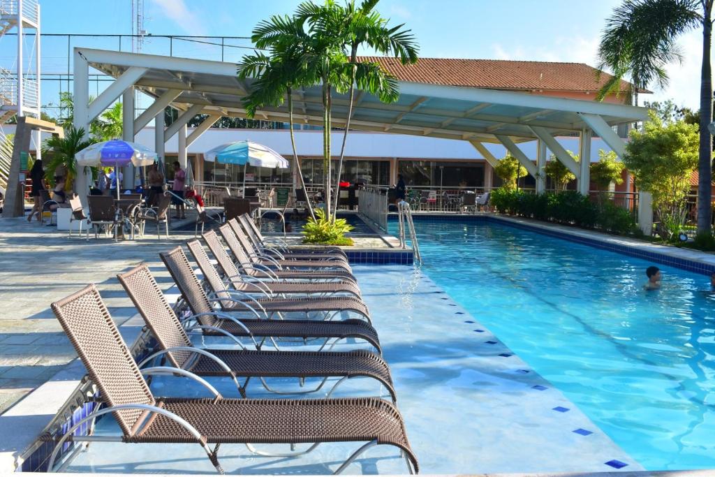 a swimming pool with lounge chairs in a resort at OFERTA - Fiori DiRoma Caldas Novas - Térreo - Parque Aquático 24h in Caldas Novas