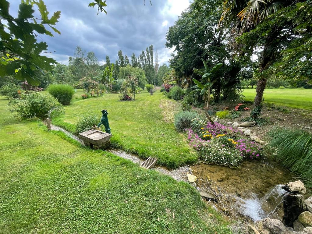 un jardin avec une cascade et un ruisseau dans l'établissement La Maison des cressonnières, à Saint-Pardoux-du-Breuil