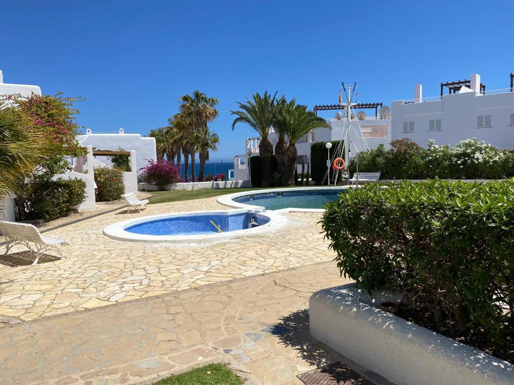 a swimming pool in the middle of a resort at Casa Los Remos in La Marina de la Torre