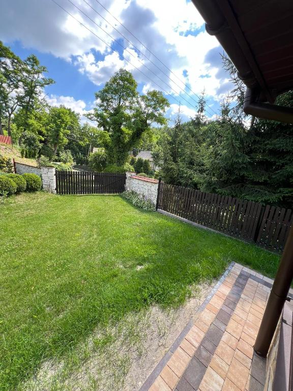 a backyard with a fence and a grass yard at Siedlisko Opoka okolice Sandomierza i Kazimierza Dolnego in Opoka Duża