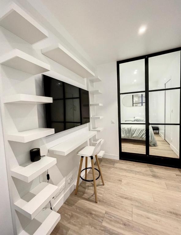 Cette chambre dispose d'étagères blanches, d'une table et d'une fenêtre. dans l'établissement Chez Julie, à Fontainebleau