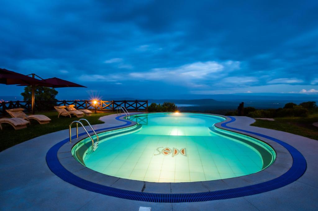 a swimming pool in a resort at night at Lake Nakuru Sopa Lodge in Nakuru