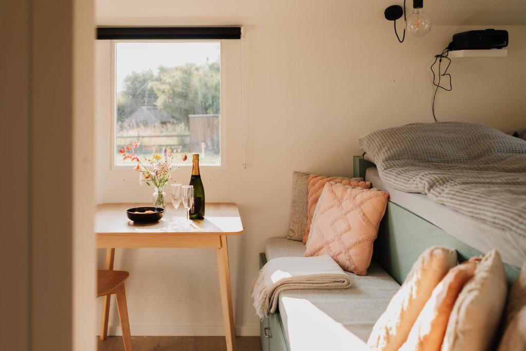 una camera con un letto, un tavolo e una finestra di Tiny House De Skure a Harelbeke