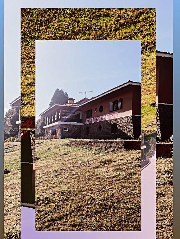 a picture of a house in a field at Villaggio D'Amore in Monte Verde