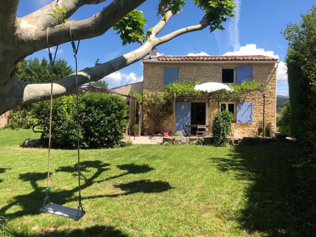 une maison avec une cour et une balançoire dans l'établissement Maison de charme provençale en pierre, à Puyvert