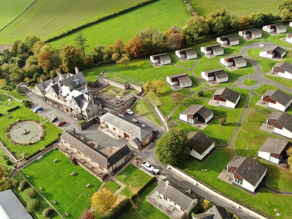 an aerial view of an old mansion with a clock at Harcombe House&nbspPet Free Bungalow in Newton Abbot