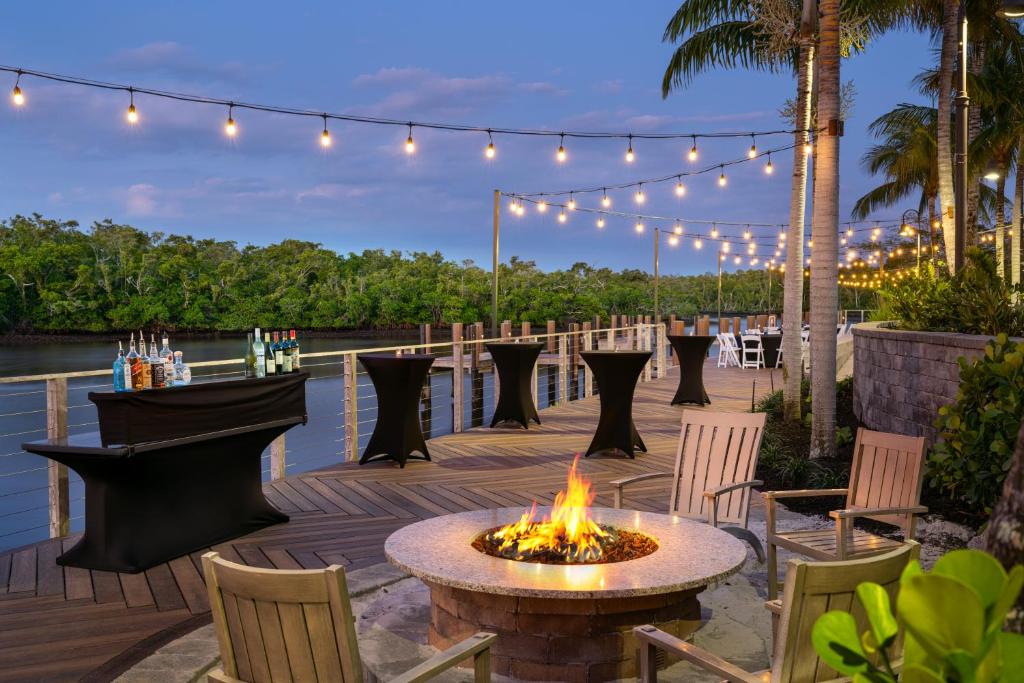 a fire pit on a deck with chairs and lights at Hyatt House Naples 5th Avenue in Naples