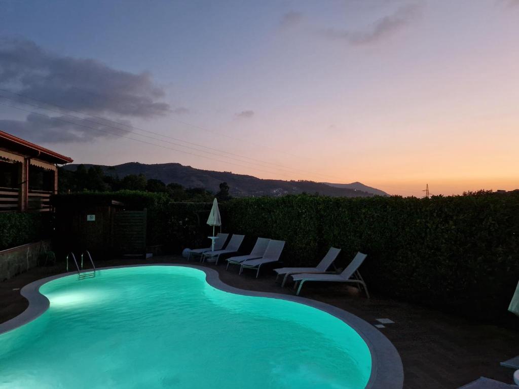 a swimming pool with lounge chairs and a sunset at B&B Artemide in Agropoli