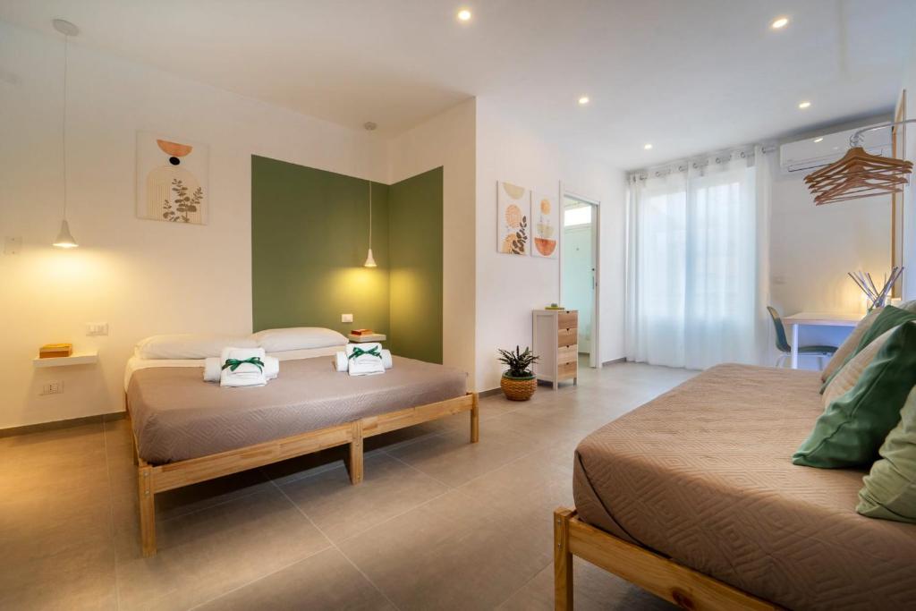 a bedroom with two beds and a living room at MamErì central rooms in Castellammare del Golfo
