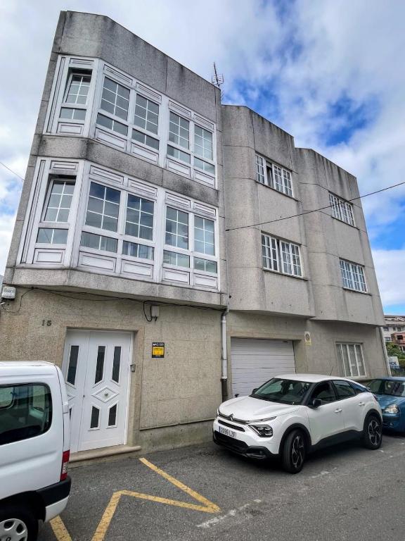 a white car parked in front of a building at apartamento Sol in O Grove