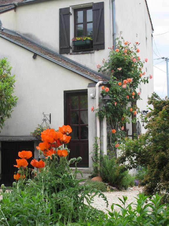 La FALLONNIERE في Bois-le-Roi: منزل أمامه أزهار برتقالية